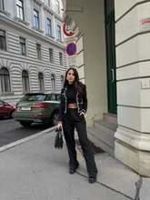 a lady in black cropped jacket with black pants